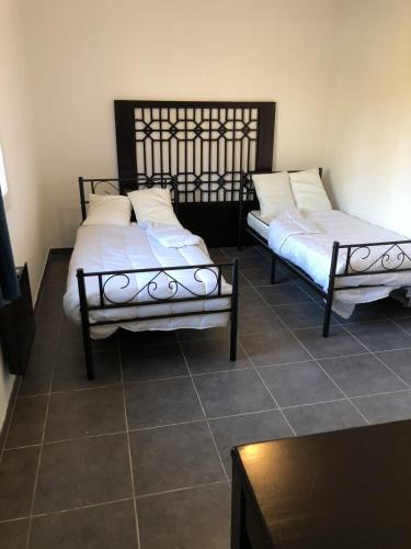 duas camas sentadas uma ao lado da outra num quarto em Maison neuve 8 couchages em Ginestet