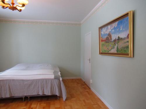 a bedroom with a bed and a painting on the wall at Conciërgewoning van het gerechtsgebouw. in Ragunda