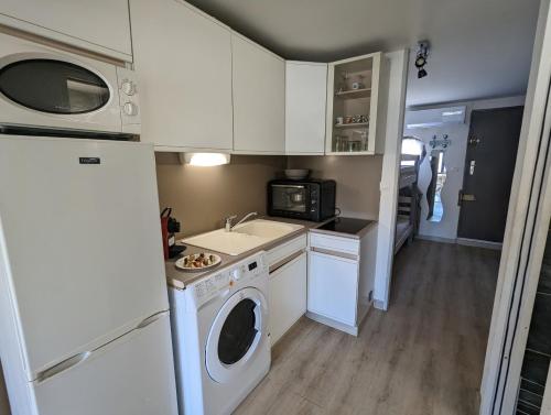 une cuisine avec un lave-linge et un micro-ondes dans l'établissement Sol-y-Days Port Royal, Grand studio 4 couchages bien équipé en Centre Ville, au Grau-du-Roi