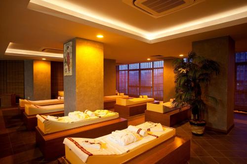 a room with four beds and a potted plant at Limak Lara Deluxe Hotel & Resort Antalya in Lara