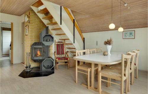 a dining room with a table and a wood stove at Three-Bedroom Holiday Home In Otterup in Otterup