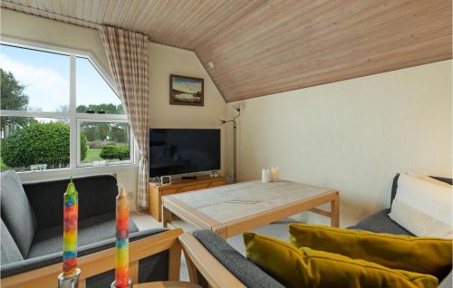 a living room with a table and a tv at Three-Bedroom Holiday Home In Otterup in Otterup