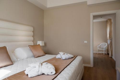 a bedroom with a bed with towels on it at Europa Grand Hotel in Lerici