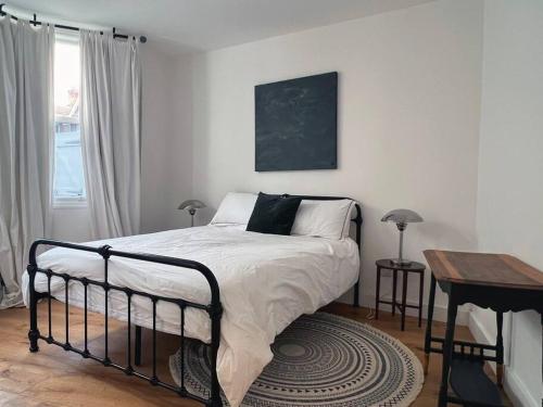 1 dormitorio con cama, mesa y ventana en Poets Rest, free parking, EV socket fees apply walk to beach, en Brighton & Hove