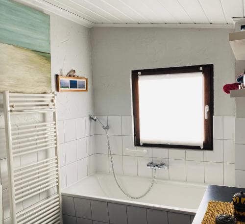 a bathroom with a bath tub and a window at Gelbes Haus bei Mardorf am Steinhuder Meer in Rehburg-Loccum