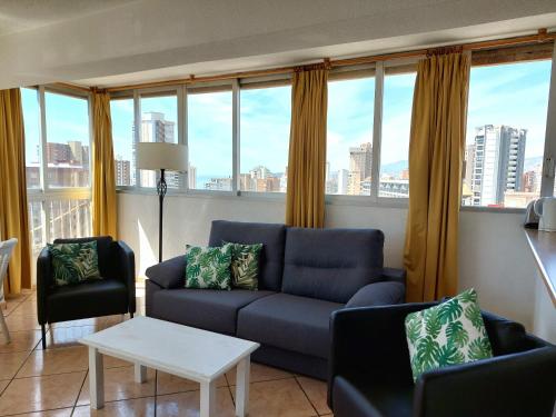 a living room with a couch and a table and windows at Best View - Welcome Penthouse Apartamentos Karola in Benidorm