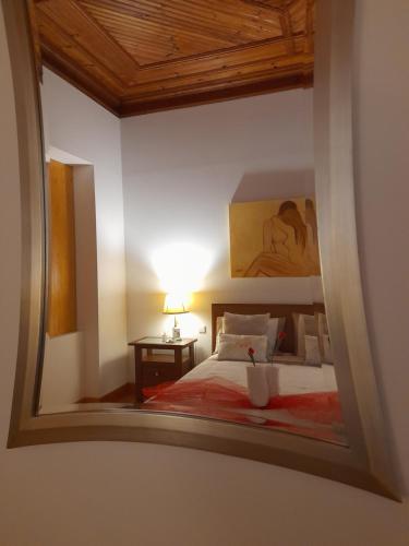 a mirror reflection of a bedroom with a bed at Casa Afonso - Passadiços do Paço in Aveiro