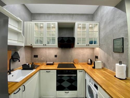 a kitchen with white cabinets and a sink at Athenian urban experience in Athens