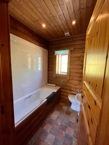 y baño grande con bañera y aseo. en Beautiful 2 Bedroom Log Cabin With Private Hot Tub - Elm, en Leominster