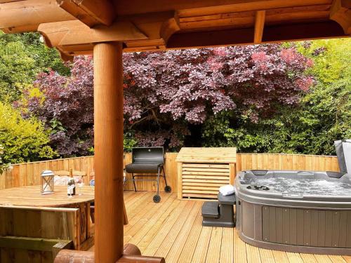 a wooden deck with a hot tub and a pergola at Beautiful 2 Bedroom Log Cabin With Private Hot Tub - Elm in Leominster