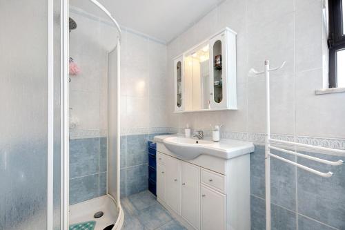 a white bathroom with a sink and a shower at Vila Portimão T5 com Piscina in Portimão