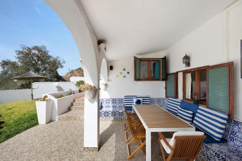 a patio with a wooden table and chairs at Vila Portimão T5 com Piscina in Portimão