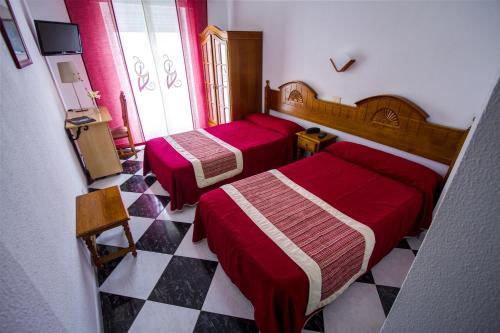 a hotel room with two beds and a checker floor at Hotel Mediante in Ribadeo