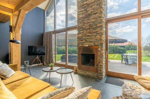 a living room with a fireplace and a couch at Buytenplaats Villa 181 in De Koog
