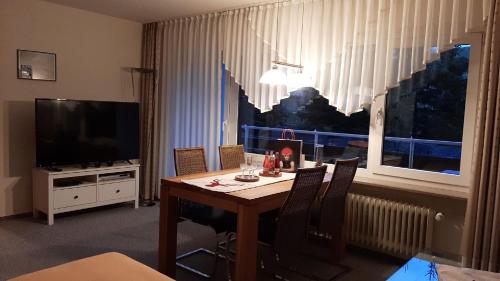 een eetkamer met een tafel en een groot raam bij Apartment Elena in Schönwald