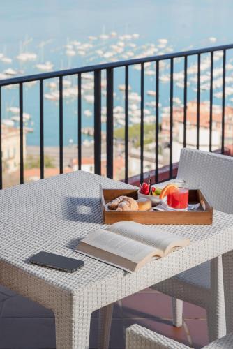a table with an open book on a balcony at Europa Grand Hotel in Lerici