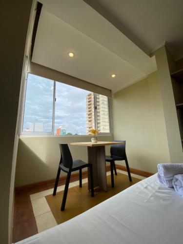 a bedroom with a table and two chairs and a window at Los geranios Villa Sarita Posadas - 3B in Posadas