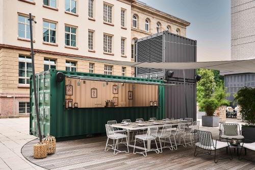 a patio with a table and chairs and a building at FREIgeist Göttingen Innenstadt, A Member of Design Hotels in Göttingen