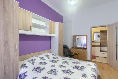 a bedroom with a bed with a purple wall at Aida Pula apartment in Pula