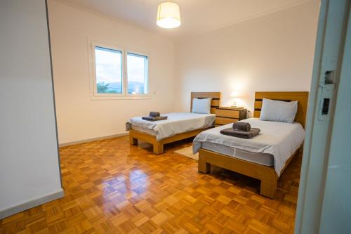 a room with two beds and a window at Prestígio Home in Alvito