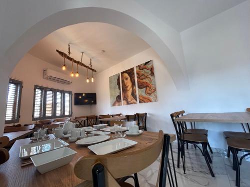 uma sala de jantar com uma grande mesa de madeira e cadeiras em Royal Goddess Guest House, Walled City em Famagusta