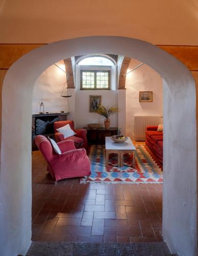 a living room with a red couch and a table at Castello del Calcione in Lucignano
