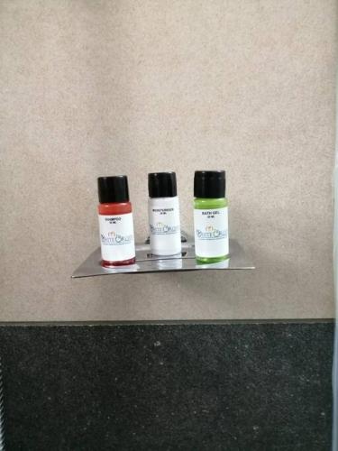 three bottles of medication sitting on a shelf at The White Orchid Luxury Service Apartments in Ernakulam