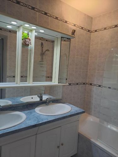 une salle de bain avec deux lavabos et une baignoire dans l'établissement Belle situation au calme, à Mandelieu-la-Napoule