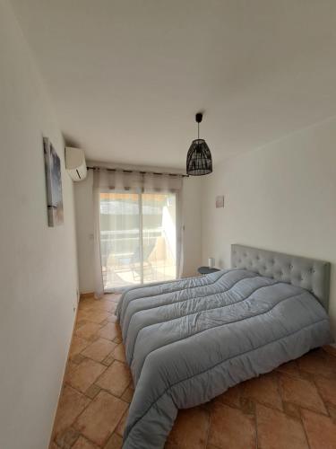 een slaapkamer met een groot bed in een witte kamer bij Situation idéale au calme et tout confort ! in Mandelieu-la-Napoule