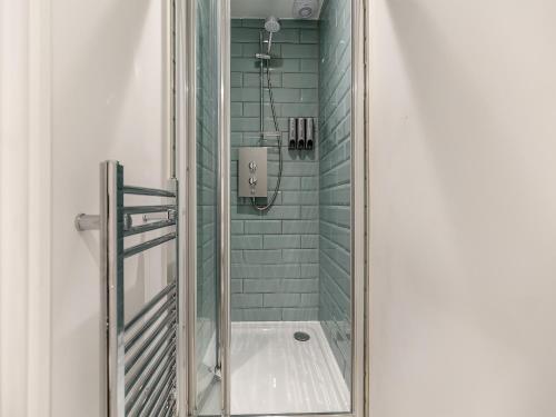 a bathroom with a shower with green tiles at St Mildreds Villa in Ramsgate