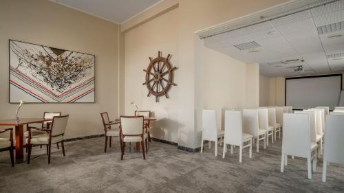 a conference room with white chairs and a table and a board at Europa Grand Hotel in Lerici
