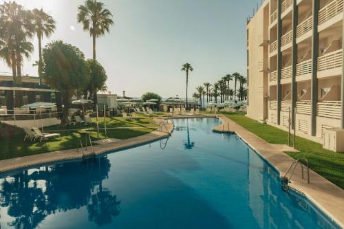 a large swimming pool next to a building at Medplaya Hotel Pez Espada in Torremolinos