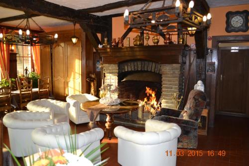 a living room with a fireplace and a table and chairs at Auberge Au Naturel des Ardennes in Rochehaut