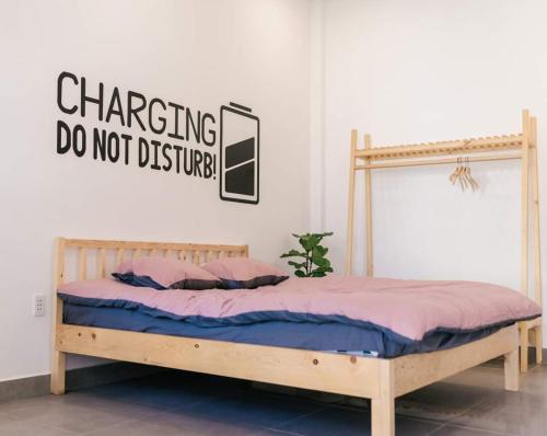 a bed with a sign that reads changing do not disturb at Nhà của Te - Homestay & Tea room in Da Nang