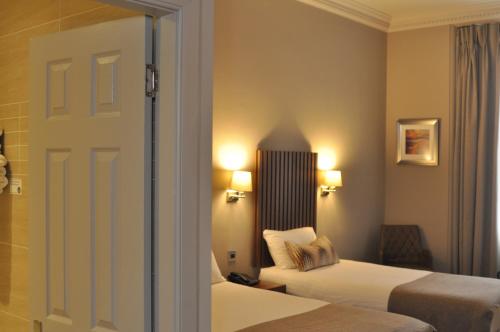 a hotel room with two beds and a door at Frederick House Hotel in Edinburgh