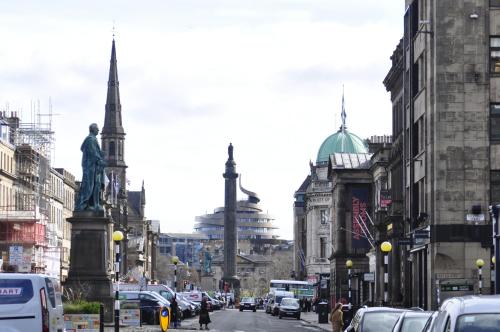 a busy city street with cars and buildings and a statue at Frederick House Hotel in Edinburgh