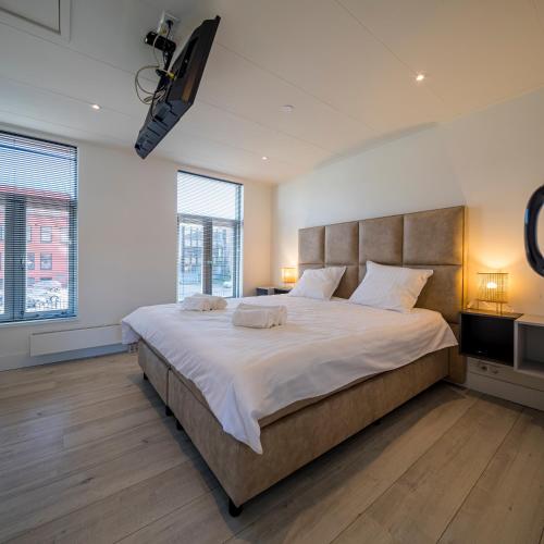 a bedroom with a large bed with two towels on it at Luxury City Home Alkmaar nearby Amsterdam. in Alkmaar