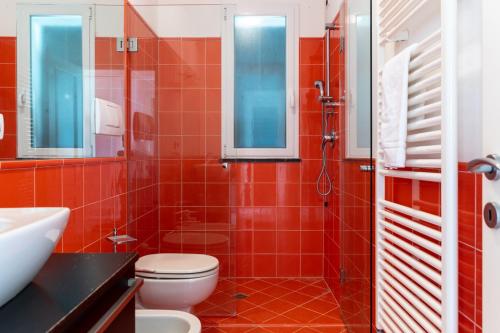 a red bathroom with a toilet and a shower at L'Ulivo di Cecilia in Alassio