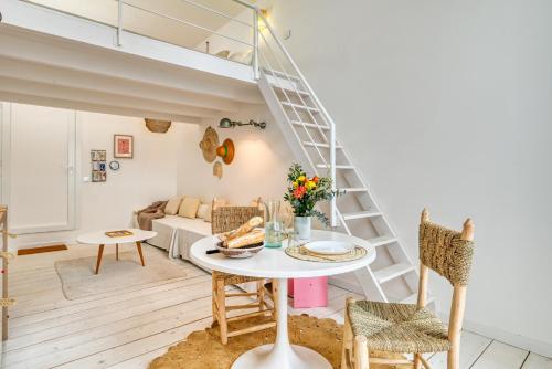 - un salon avec un escalier, une table et des chaises dans l'établissement L'Octopus - Petit patio estival, à Marseille