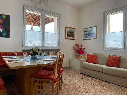 uma sala de estar com uma mesa e um sofá em Il nido del merlo Parcheggio e giardino em Verbania