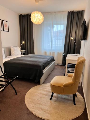 a bedroom with a bed and a chair and a table at Hotel Abtshof in Halberstadt