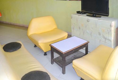 a waiting room with two chairs and a table and a tv at RedDoorz @ Limelily Pension Inn General Santos City in General Santos