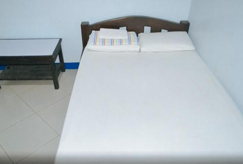 a large white bed in a room with a table at RedDoorz @ Limelily Pension Inn General Santos City in General Santos