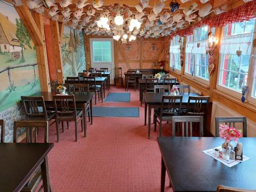 uma sala de jantar com mesas e cadeiras num restaurante em Pension Zum Erzgebirge em Kurort Altenberg