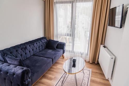 a living room with a black couch and a glass table at QZEN SUİT APART OTEL in Trabzon