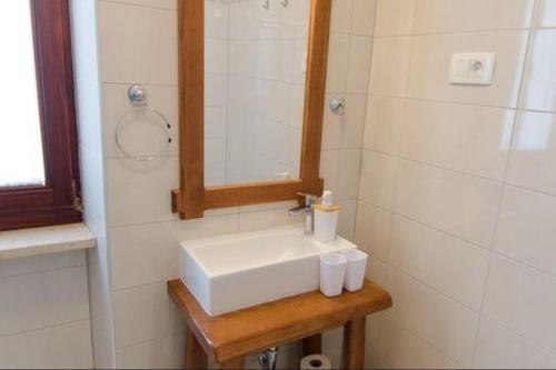 y baño con lavabo blanco y espejo. en Rooms Casa Rossa in Motovun central Istria, en Motovun