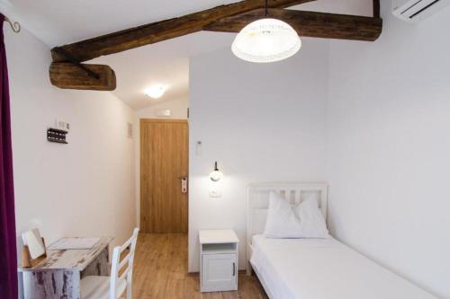 1 Schlafzimmer mit 2 Betten und einem Schreibtisch in einem Zimmer in der Unterkunft Rooms Casa Rossa in Motovun central Istria in Motovun