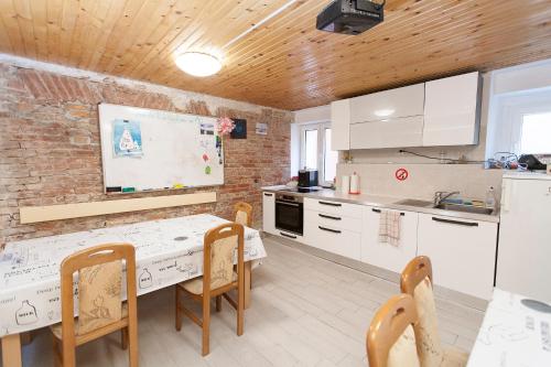 une cuisine avec une table, des chaises et un comptoir blanc dans l'établissement Sailing House Piran, à Piran