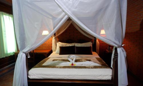 a bedroom with a bed with a canopy at Danasari Homestay in Ubud
