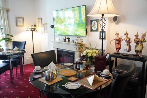 a living room with a table and a fireplace at Marlborough Guest House B & B in Tenby